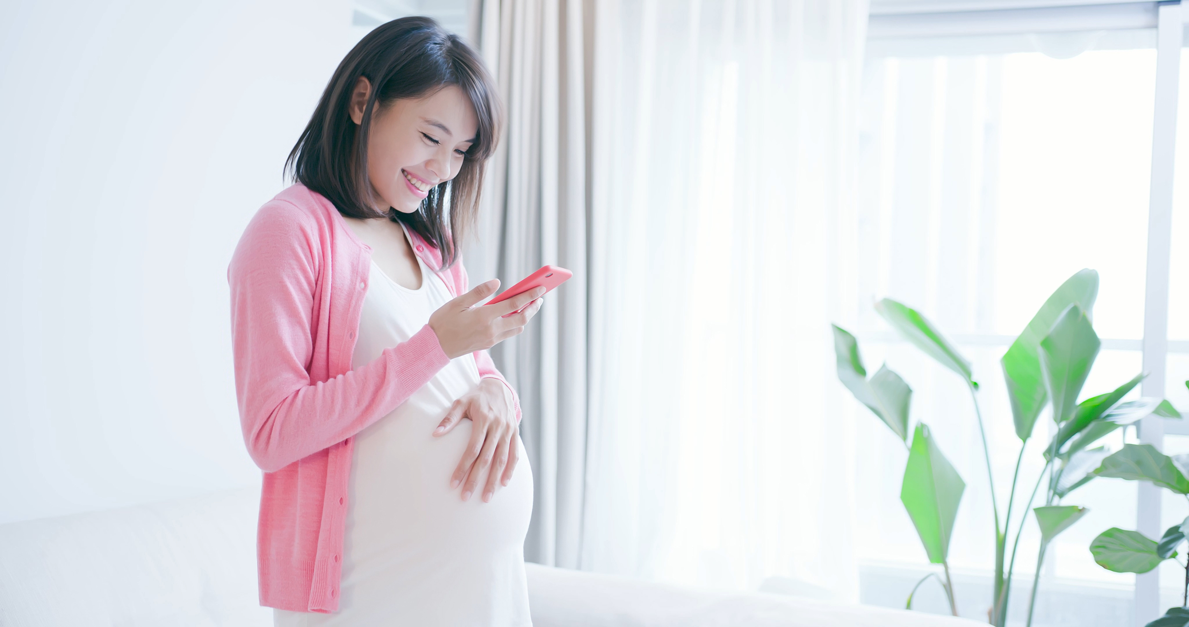 Pregnant woman smiling at phone